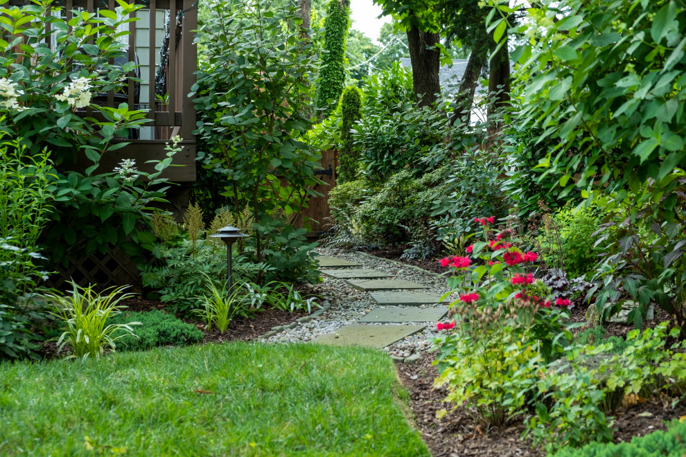 Inspiration for a small backyard partial sun garden in New York with with path and gravel.