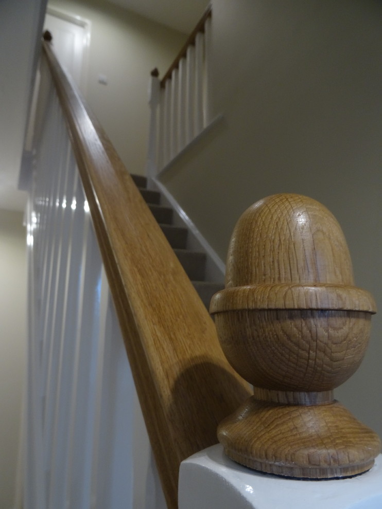 Inspiration pour un escalier droit traditionnel avec des marches en moquette, des contremarches en moquette et un garde-corps en bois.