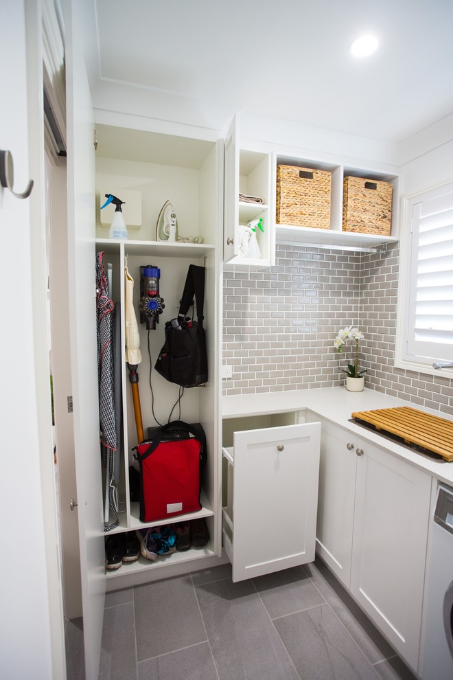 Small traditional l-shaped dedicated laundry room in Brisbane with a single-bowl sink, shaker cabinets, white cabinets, quartz benchtops, white walls, porcelain floors, grey floor and white benchtop.