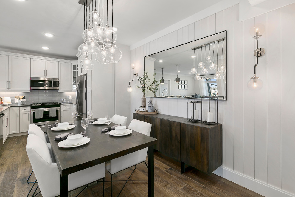 Inspiration for a transitional dining room in New York with white walls, medium hardwood floors and brown floor.