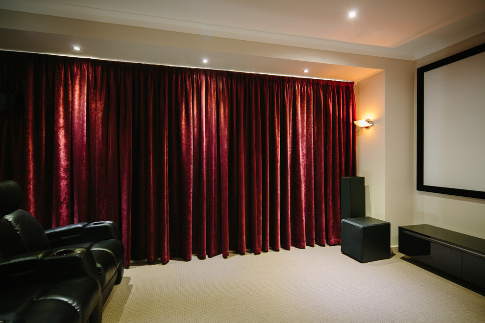 Photo of a large modern enclosed home theatre in Melbourne with red walls, a projector screen and beige floor.