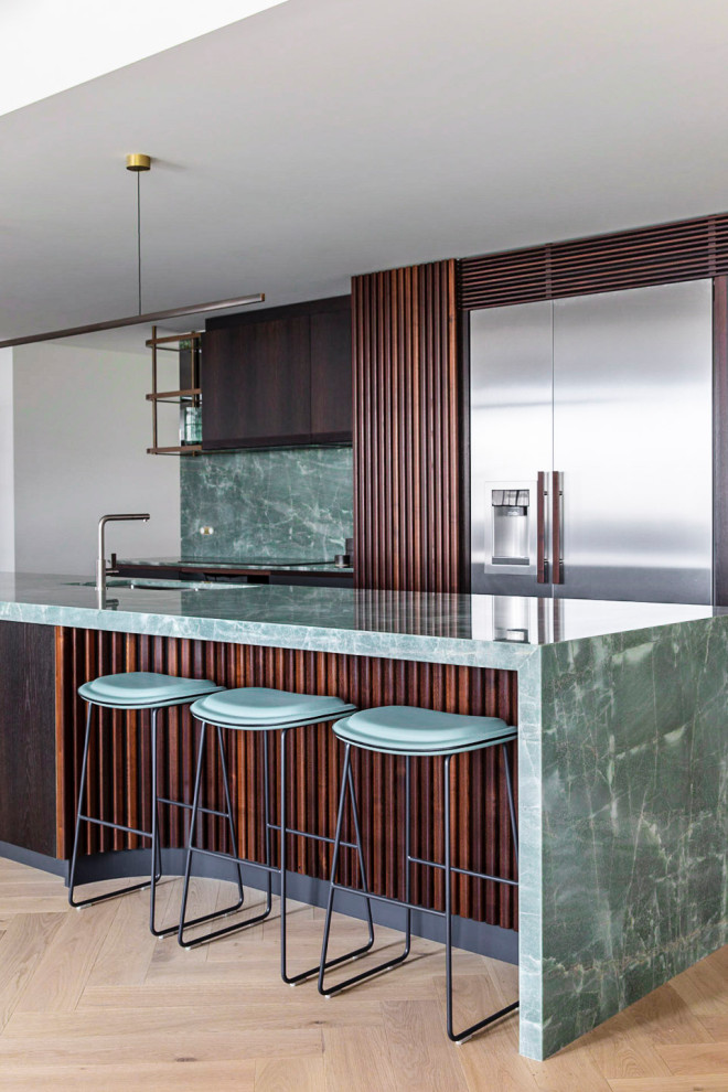 Photo of a large contemporary galley open plan kitchen in Sydney with an undermount sink, flat-panel cabinets, dark wood cabinets, quartzite benchtops, green splashback, stone slab splashback, stainless steel appliances, with island and green benchtop.