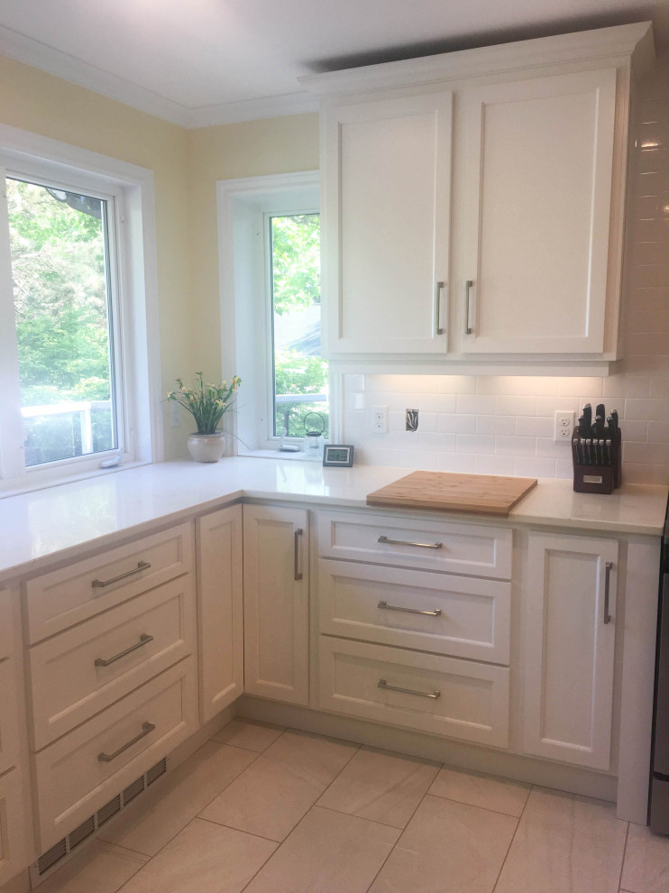 Eat-in kitchen - mid-sized transitional u-shaped porcelain tile and gray floor eat-in kitchen idea with an undermount sink, shaker cabinets, white cabinets, quartz countertops, white backsplash, subway tile backsplash, stainless steel appliances, a peninsula and beige countertops