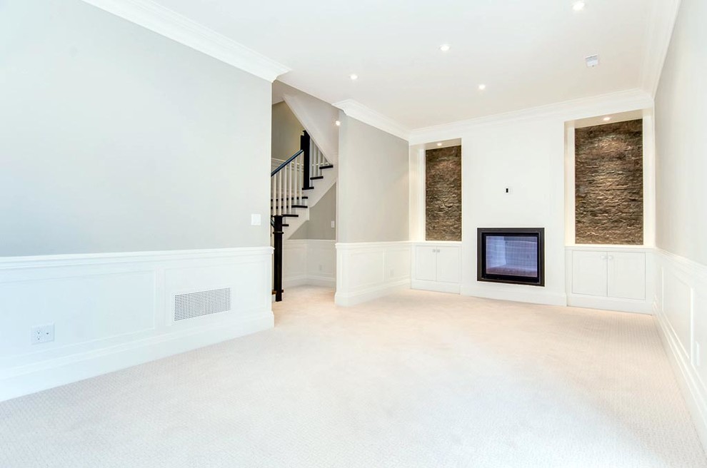 Example of a large transitional walk-out carpeted basement design in Toronto with beige walls and a standard fireplace