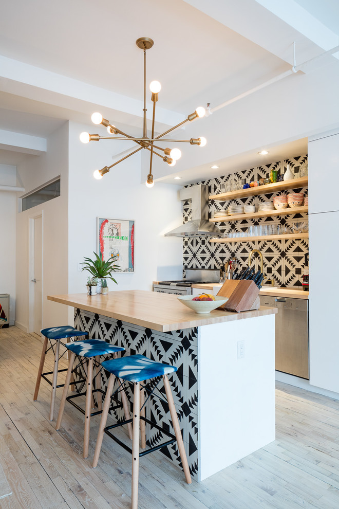 Inspiration for an eclectic open plan kitchen in New York with a drop-in sink, open cabinets, white cabinets, wood benchtops, multi-coloured splashback, cement tile splashback, stainless steel appliances, light hardwood floors, with island and beige floor.