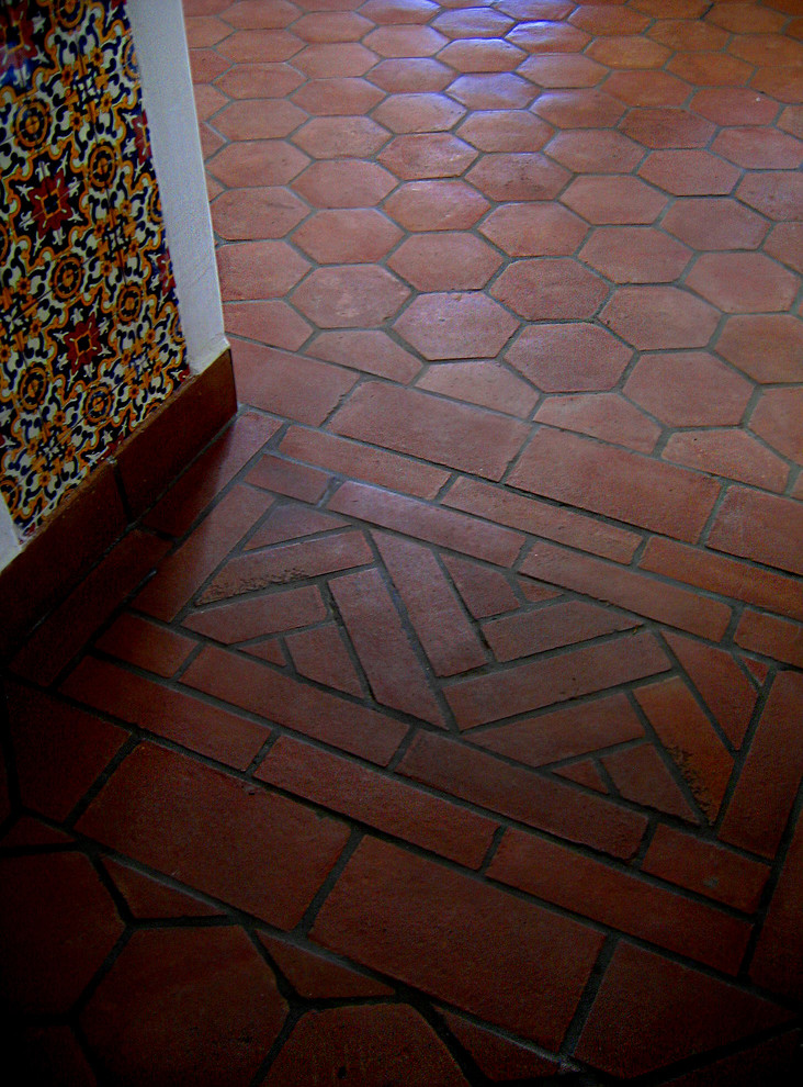 Inspiration for a mid-sized mediterranean hallway in Santa Barbara with white walls, terra-cotta floors and red floor.