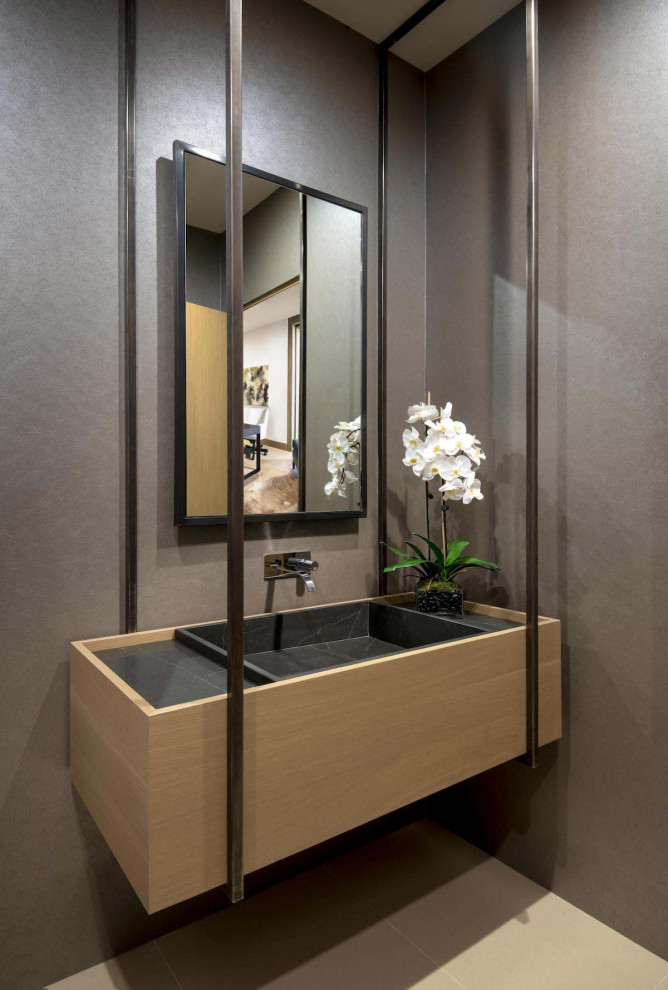 Design ideas for an expansive contemporary powder room in Phoenix with white walls, medium hardwood floors, flat-panel cabinets, medium wood cabinets, a one-piece toilet, beige tile, porcelain tile, an undermount sink, engineered quartz benchtops, beige floor, white benchtops and a built-in vanity.