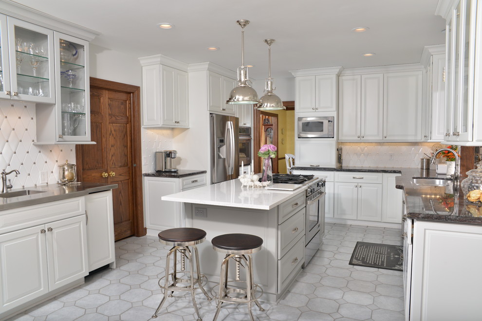 Design ideas for a large traditional u-shaped separate kitchen in Cleveland with a double-bowl sink, raised-panel cabinets, white cabinets, granite benchtops, white splashback, ceramic splashback, stainless steel appliances, with island and grey floor.