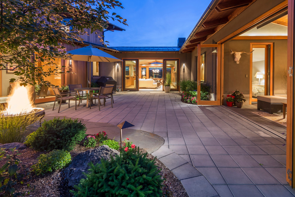 Photo of a mid-sized contemporary courtyard partial sun garden for summer in Portland with a fire feature and concrete pavers.