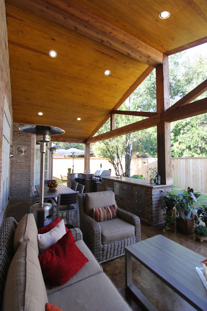 Inspiration for a rustic backyard patio kitchen remodel in Houston with a roof extension