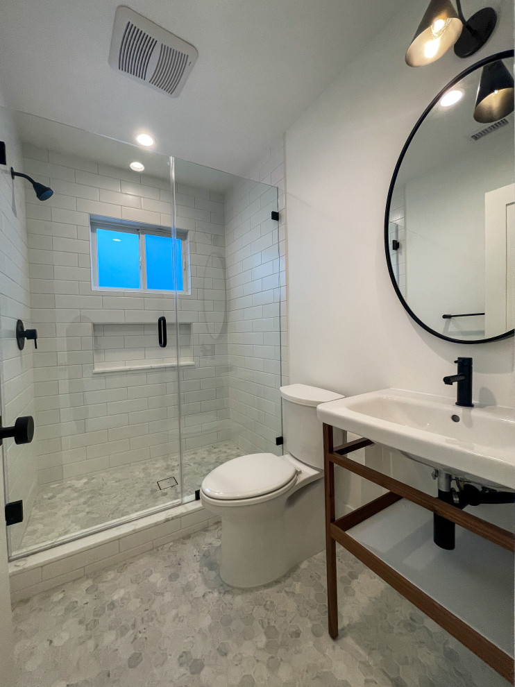 Inspiration for a small modern family bathroom in Los Angeles with white cabinets, a walk-in shower, a one-piece toilet, white tiles, metro tiles, white walls, marble flooring, a trough sink, grey floors, a hinged door, a wall niche, a single sink and a freestanding vanity unit.