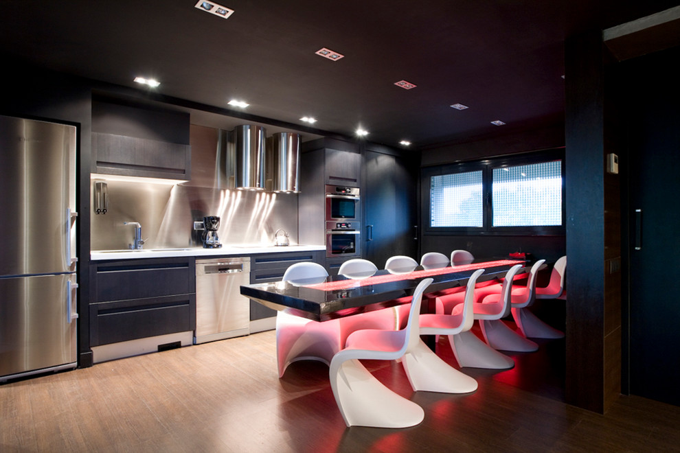 Photo of a large contemporary single-wall eat-in kitchen in Barcelona with flat-panel cabinets, black cabinets, metallic splashback, stainless steel appliances, medium hardwood floors and no island.