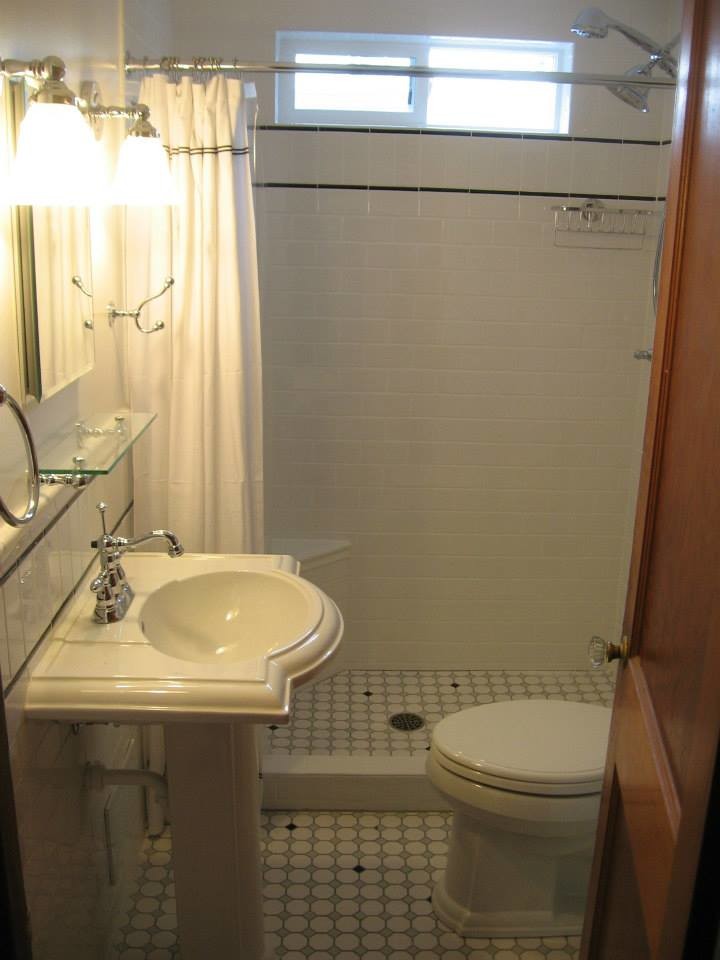 Example of a mosaic tile floor doorless shower design with white walls