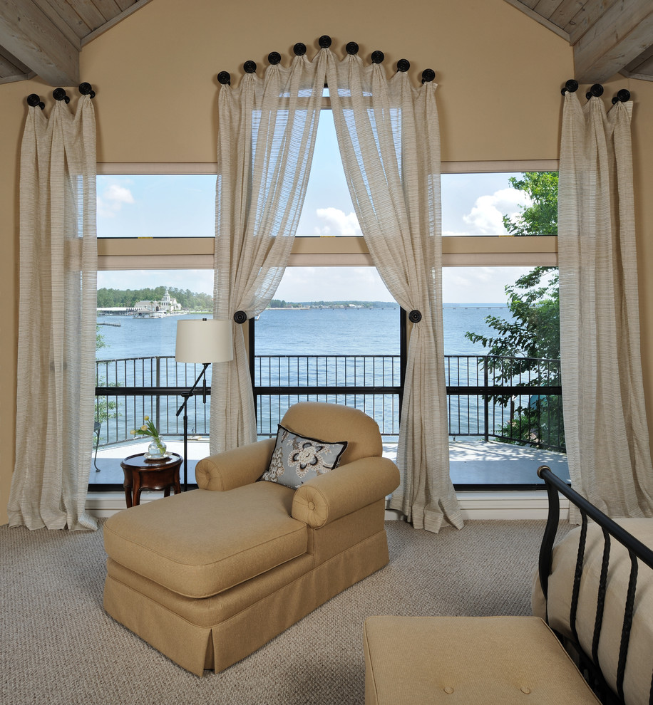 Photo of a traditional master bedroom in Houston with beige walls and carpet.