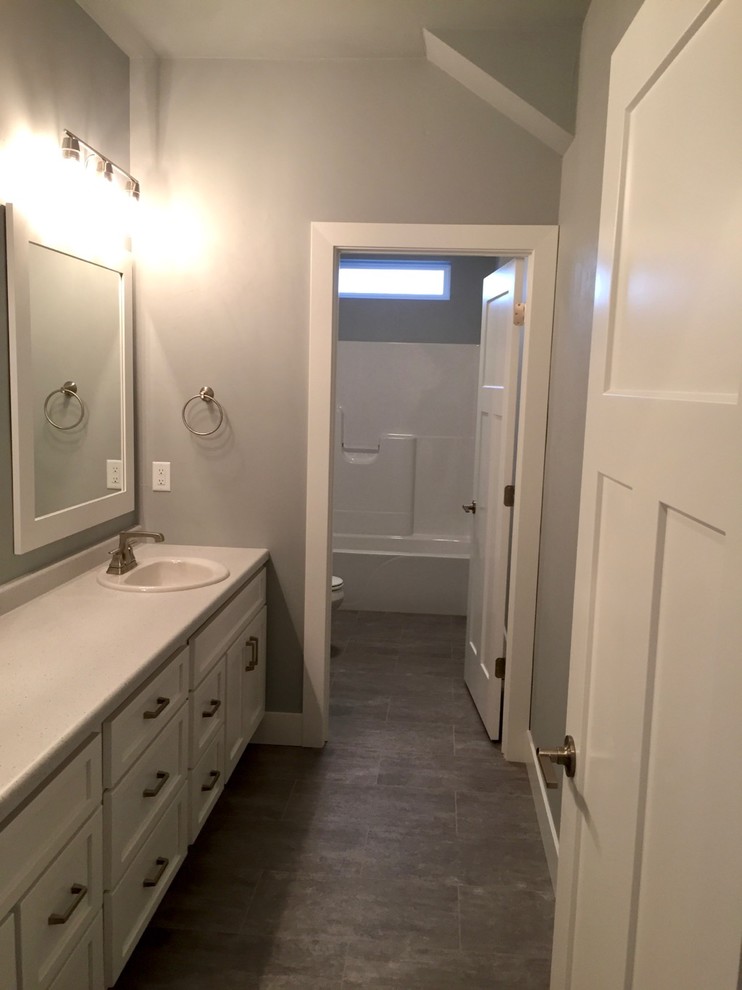 Design ideas for a large arts and crafts bathroom in Other with shaker cabinets, white cabinets, an alcove tub, a shower/bathtub combo, grey walls, vinyl floors and a drop-in sink.