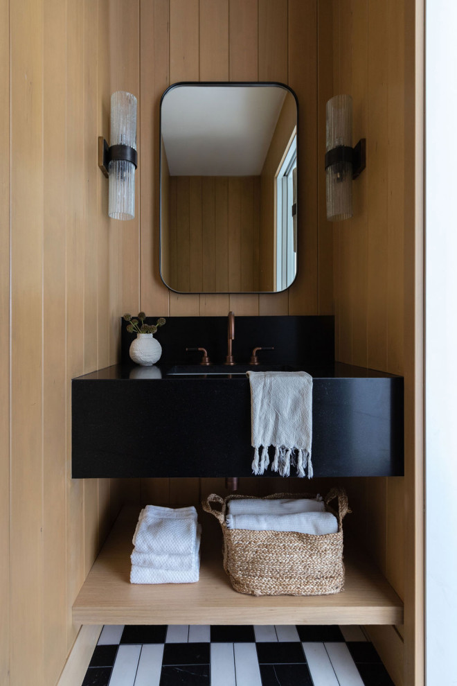 Cette image montre un petit WC et toilettes marin en bois clair avec un placard sans porte, un sol en marbre, un lavabo posé, un plan de toilette en marbre, un sol multicolore, un plan de toilette noir, meuble-lavabo suspendu et du lambris.