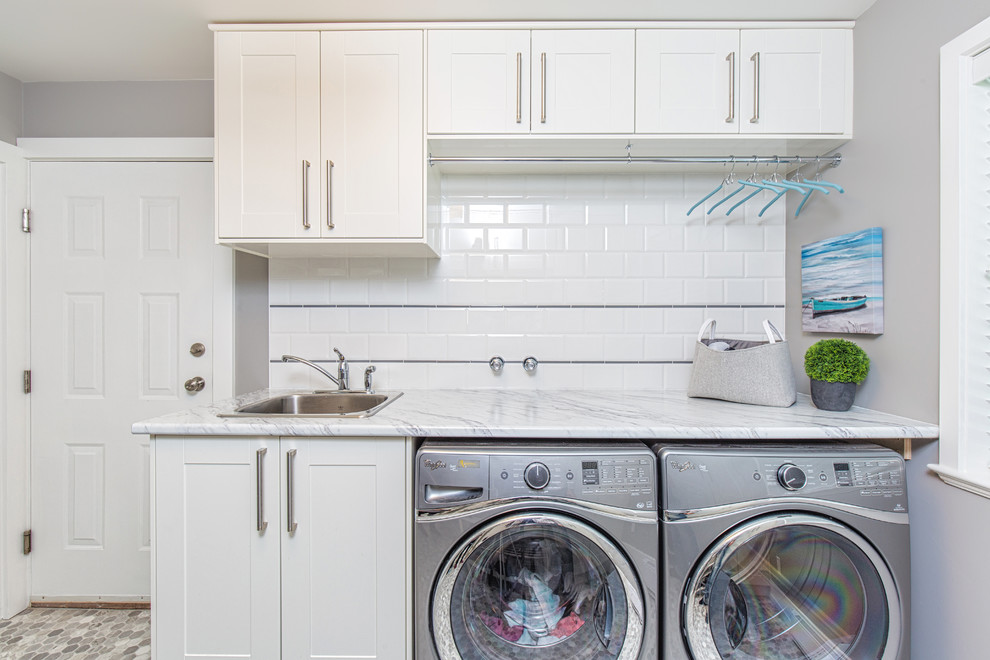 Photo of a mid-sized contemporary galley dedicated laundry room in Vancouver with a drop-in sink, shaker cabinets, white cabinets, laminate benchtops, grey walls, dark hardwood floors and a side-by-side washer and dryer.