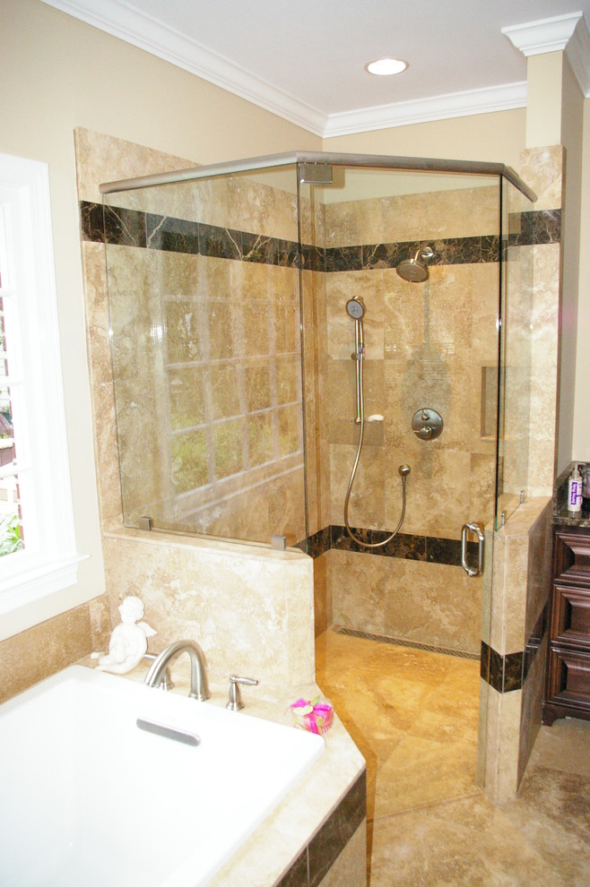 This is an example of a large traditional master bathroom in Atlanta with raised-panel cabinets, medium wood cabinets, a drop-in tub, a corner shower, beige tile, travertine, beige walls, travertine floors, granite benchtops, beige floor and a hinged shower door.