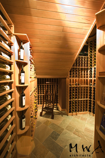 Photo of a mid-sized contemporary wine cellar in Other with storage racks, slate floors and multi-coloured floor.