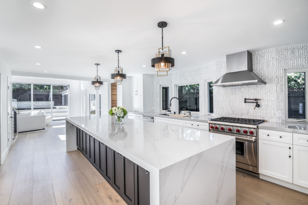 Inspiration for a large modern light wood floor and white floor eat-in kitchen remodel in San Francisco with an undermount sink, black cabinets, quartz countertops, gray backsplash, mosaic tile backsplash, stainless steel appliances, an island and white countertops