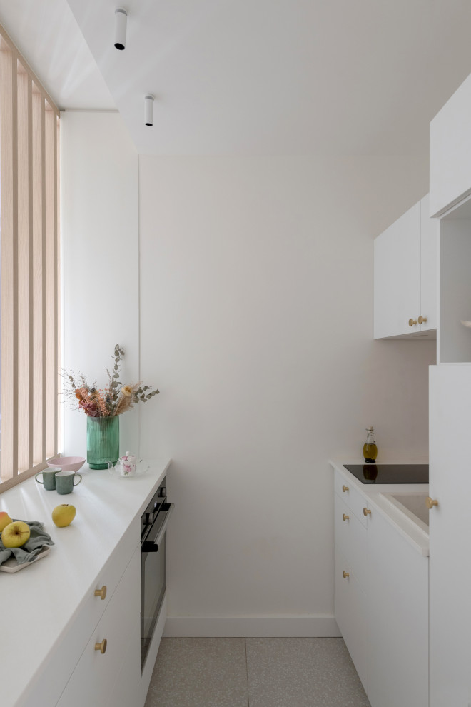 Inspiration for a small contemporary galley open plan kitchen in Lyon with a submerged sink, white cabinets, pink splashback, ceramic splashback, black appliances, ceramic flooring, no island, grey floors, white worktops and a drop ceiling.