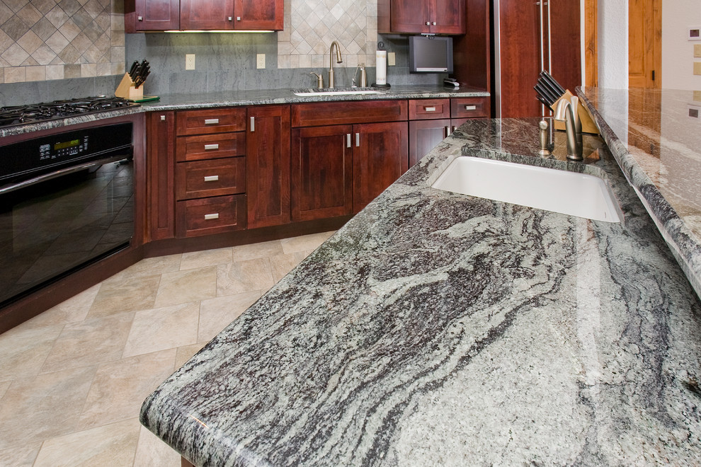 Inspiration for a large transitional l-shaped porcelain tile open concept kitchen remodel in Denver with an undermount sink, shaker cabinets, red cabinets, granite countertops, gray backsplash, stone tile backsplash, black appliances and an island