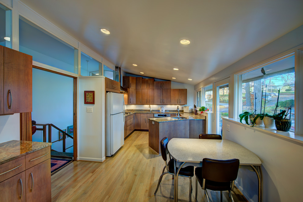 Eat-in kitchen - mid-sized transitional u-shaped light wood floor eat-in kitchen idea in DC Metro with medium tone wood cabinets, granite countertops, a peninsula, an undermount sink, flat-panel cabinets, beige backsplash, stone slab backsplash and white appliances