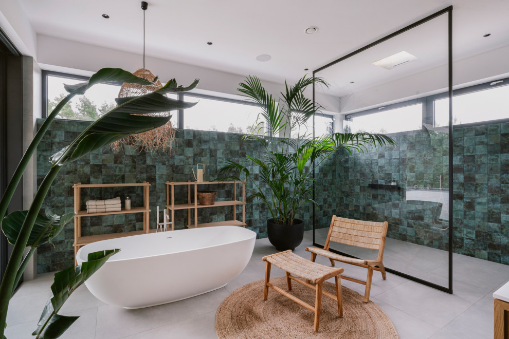 Immagine di una stanza da bagno padronale minimal con vasca freestanding, doccia a filo pavimento, piastrelle verdi, pareti bianche, pavimento grigio e doccia aperta