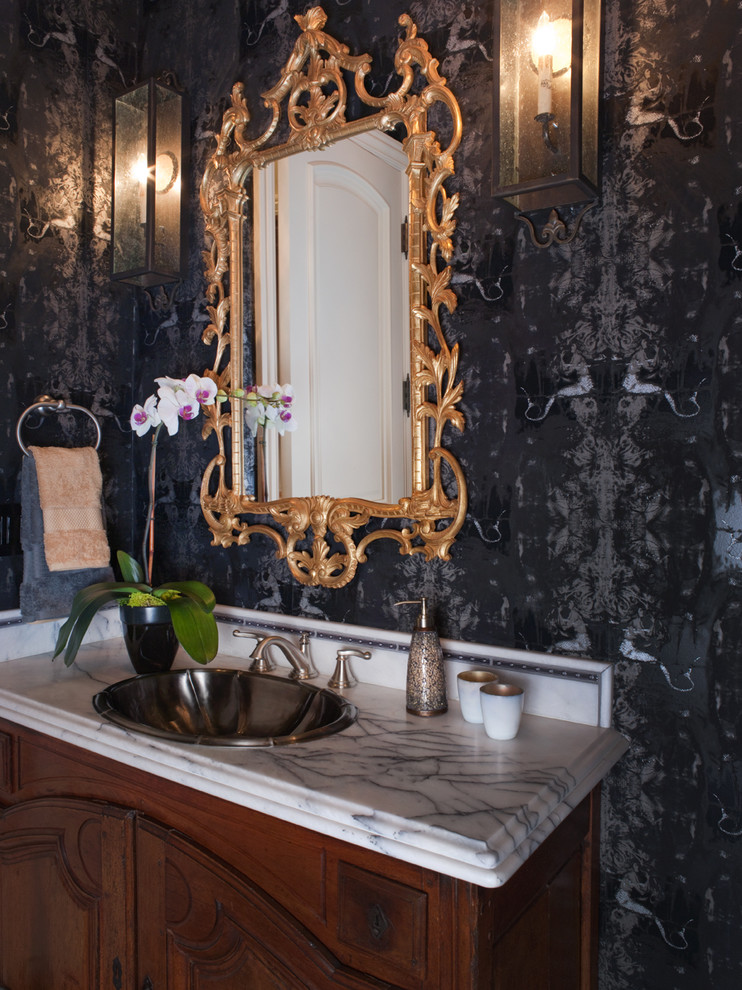 Inspiration for a mid-sized traditional powder room in San Francisco with furniture-like cabinets, dark wood cabinets, black walls, a drop-in sink, marble benchtops and white benchtops.