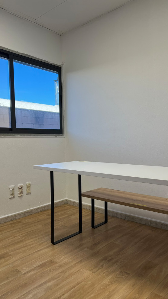 Cette image montre un très grand bureau urbain avec un mur blanc, un sol en vinyl, un bureau indépendant et un sol jaune.