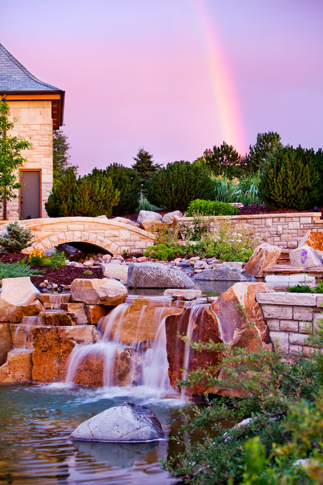 Inspiration for a large eclectic backyard full sun formal garden in Denver with a water feature and natural stone pavers.