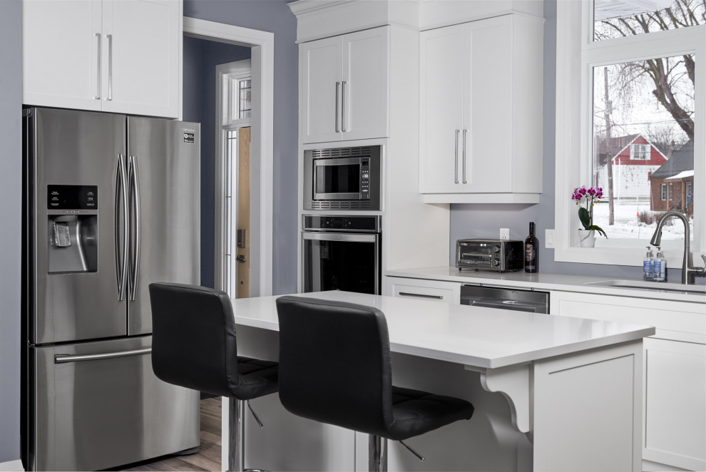 Enclosed kitchen - transitional l-shaped ceramic tile and gray floor enclosed kitchen idea in Toronto with an undermount sink, shaker cabinets, white cabinets, quartzite countertops, stainless steel appliances, an island and white countertops