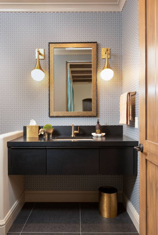 This is an example of a mid-sized midcentury powder room in Phoenix with flat-panel cabinets, black cabinets, grey walls, ceramic floors, an undermount sink, wood benchtops, black floor, black benchtops, a floating vanity and wallpaper.