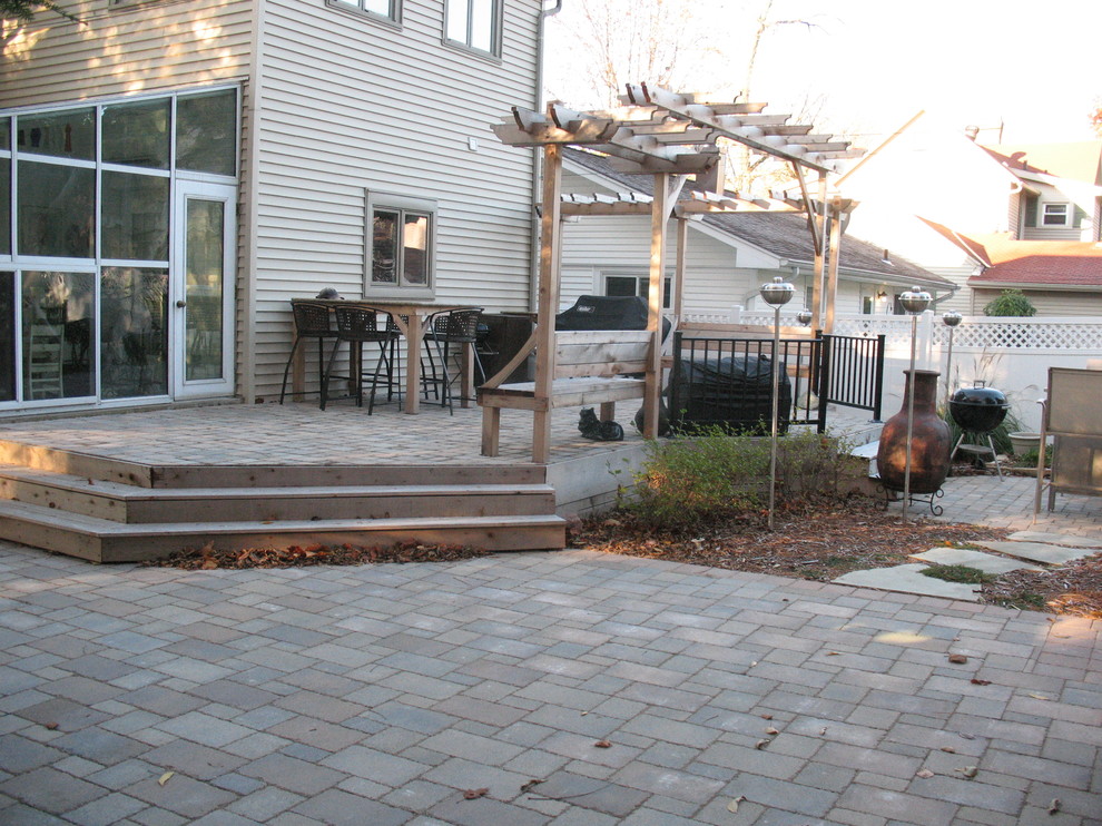 Photo of a mid-sized traditional backyard patio in Chicago with concrete pavers and a pergola.