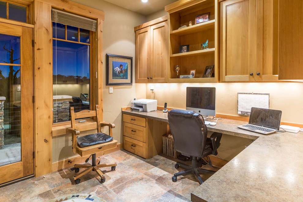 This is an example of a mid-sized country home office in Other with brown walls, ceramic floors, no fireplace and a built-in desk.