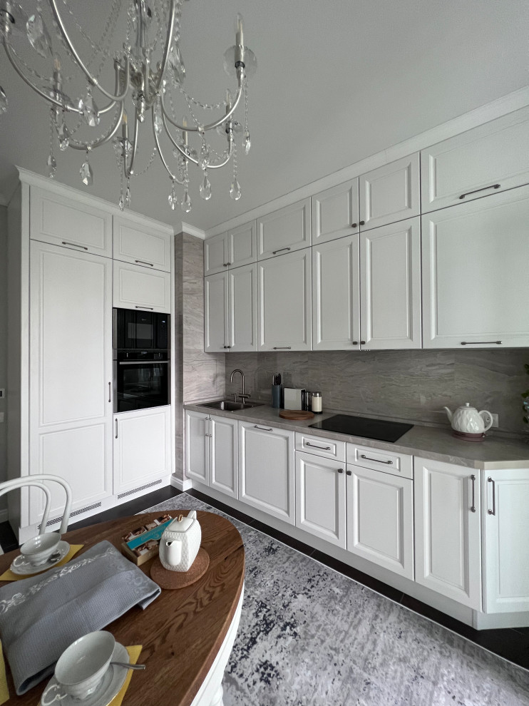 Foto de cocinas en L clásica renovada de tamaño medio cerrada con armarios con paneles con relieve, puertas de armario blancas y salpicadero de azulejos de porcelana
