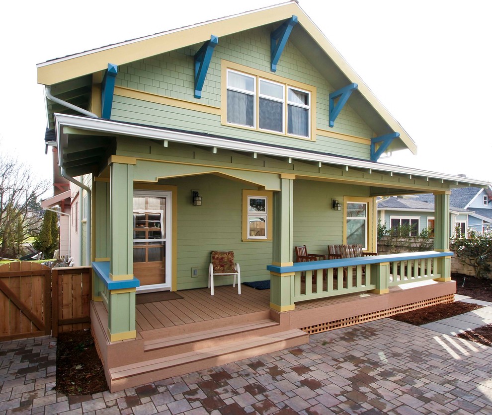Photo of an arts and crafts two-storey green exterior in Seattle with wood siding.