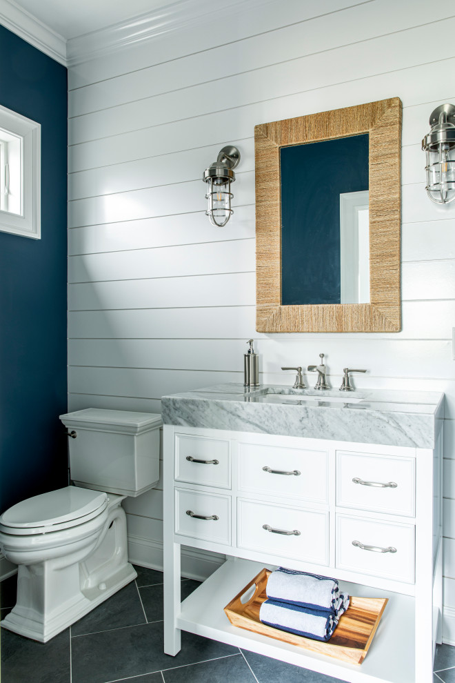 Inspiration for a beach style bathroom in New York with white cabinets, a two-piece toilet, blue walls and an undermount sink.