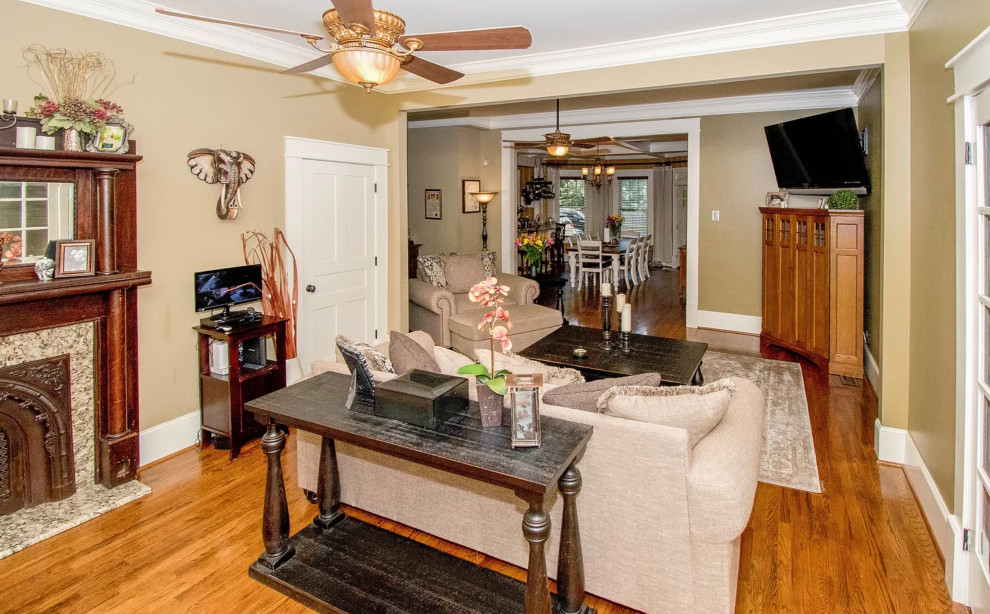 Mid-sized country enclosed family room in Raleigh with a game room, yellow walls, dark hardwood floors, a standard fireplace, a wood fireplace surround and brown floor.
