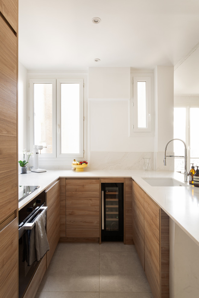 Inspiration för mellanstora moderna vitt kök, med en integrerad diskho, luckor med profilerade fronter, skåp i ljust trä, bänkskiva i kvartsit, vitt stänkskydd, stänkskydd i marmor, svarta vitvaror, en köksö och beiget golv
