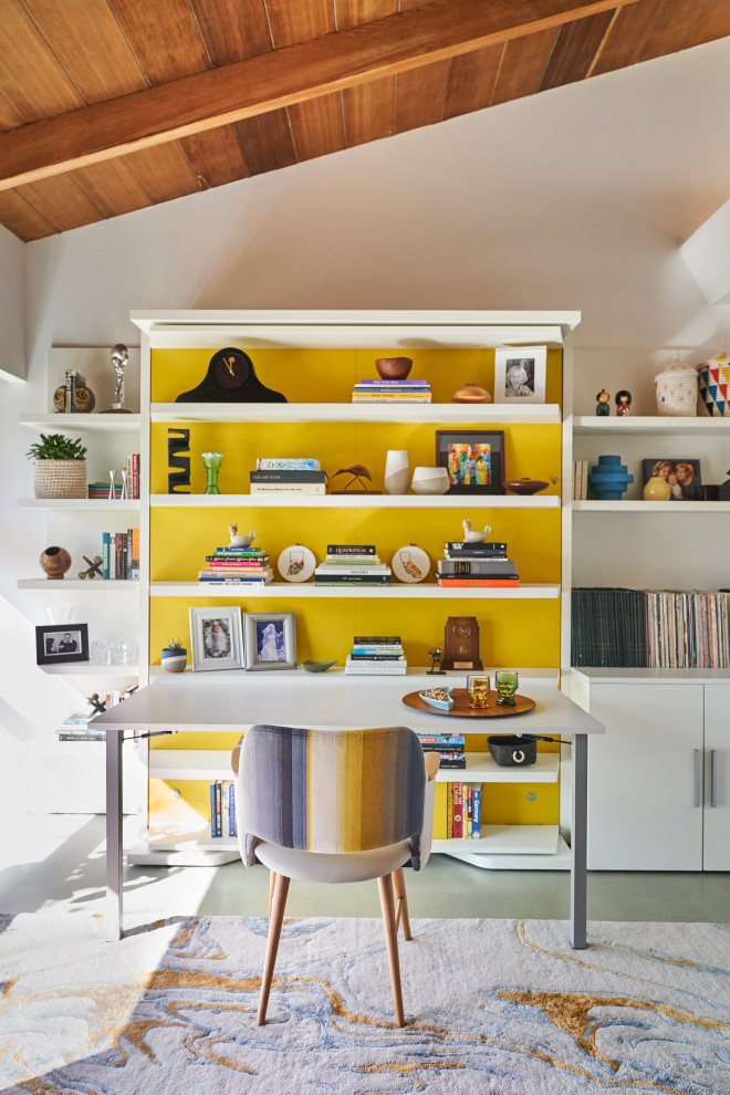 Inspiration for a mid-sized midcentury home office in San Diego with white walls, cork floors, a built-in desk, grey floor, wood walls and vaulted.
