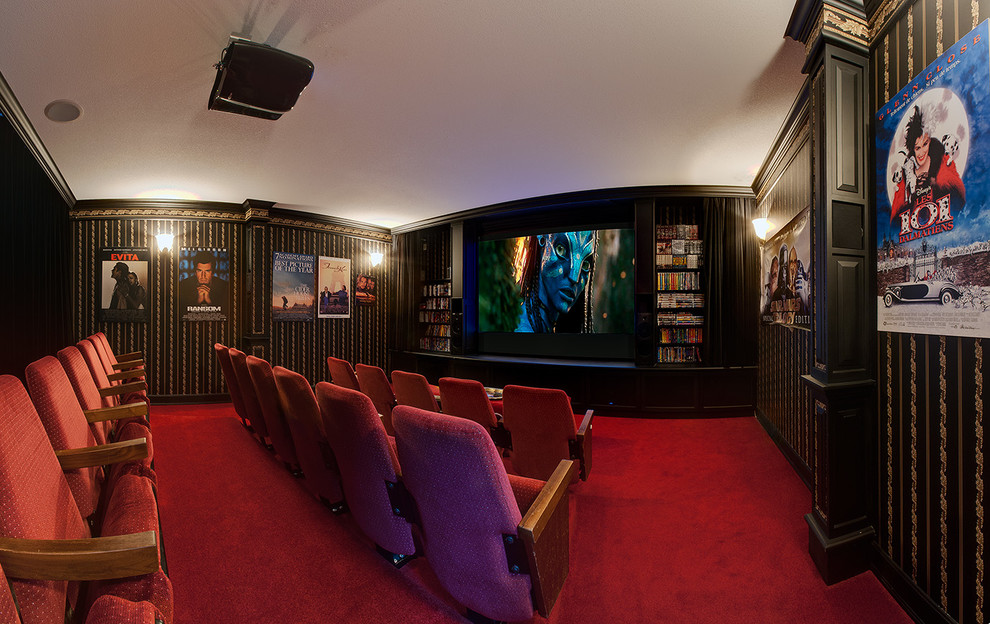 Large traditional enclosed home theatre in Calgary with multi-coloured walls, carpet, a projector screen and red floor.