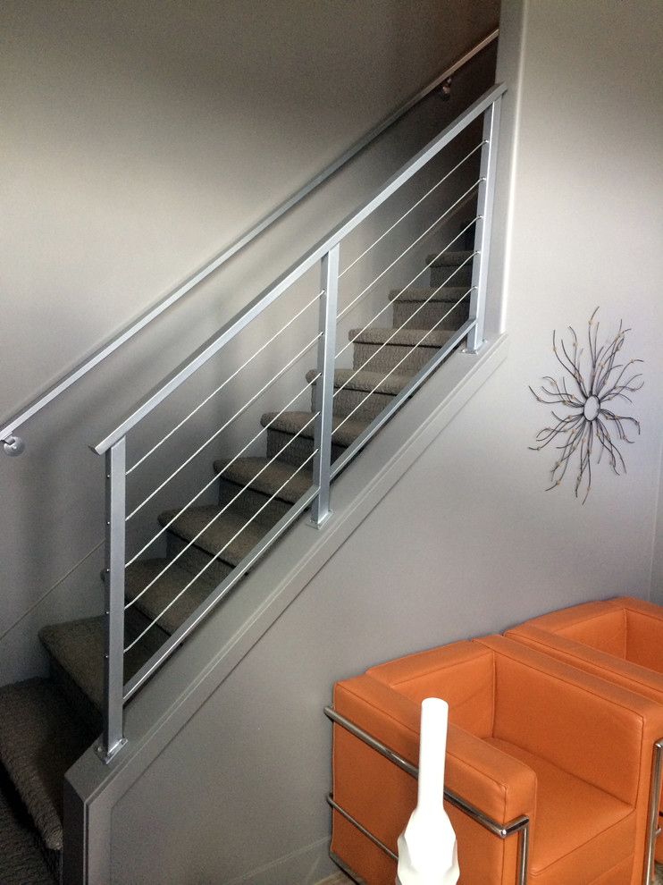 This is an example of a small transitional carpeted straight staircase in Salt Lake City with carpet risers.