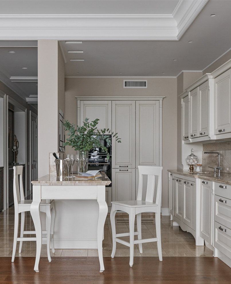 This is an example of a transitional single-wall open plan kitchen in Moscow with raised-panel cabinets, white cabinets, beige splashback, with island, beige benchtop and recessed.