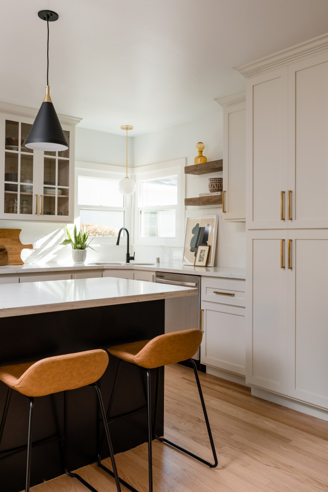 This is an example of a beach style l-shaped kitchen in Sacramento with a drop-in sink, open cabinets, white cabinets, granite benchtops, ceramic splashback, stainless steel appliances, light hardwood floors, with island, beige floor and white benchtop.