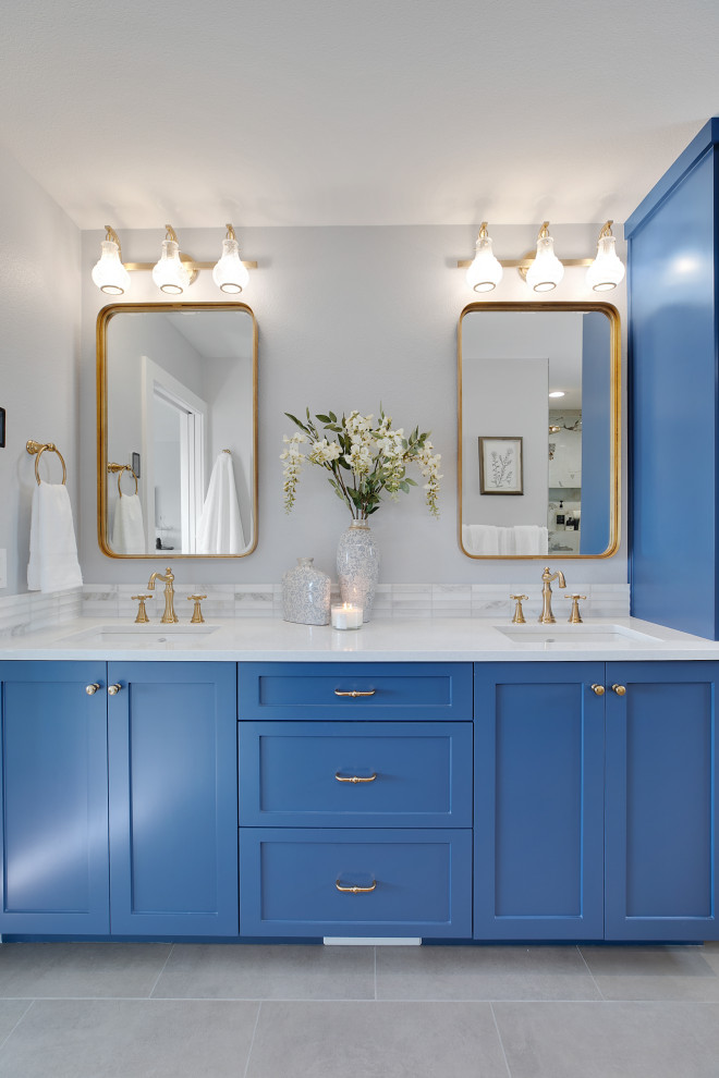Photo of a mid-sized traditional master bathroom in Portland with shaker cabinets, blue cabinets, a curbless shower, a one-piece toilet, gray tile, porcelain tile, grey walls, porcelain floors, an undermount sink, engineered quartz benchtops, grey floor, an open shower, white benchtops, a niche, a double vanity and a built-in vanity.