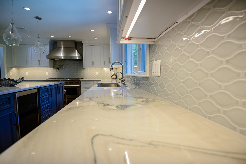 Example of a large transitional u-shaped medium tone wood floor and brown floor eat-in kitchen design in DC Metro with a farmhouse sink, recessed-panel cabinets, white cabinets, marble countertops, stainless steel appliances, an island, gray backsplash and porcelain backsplash