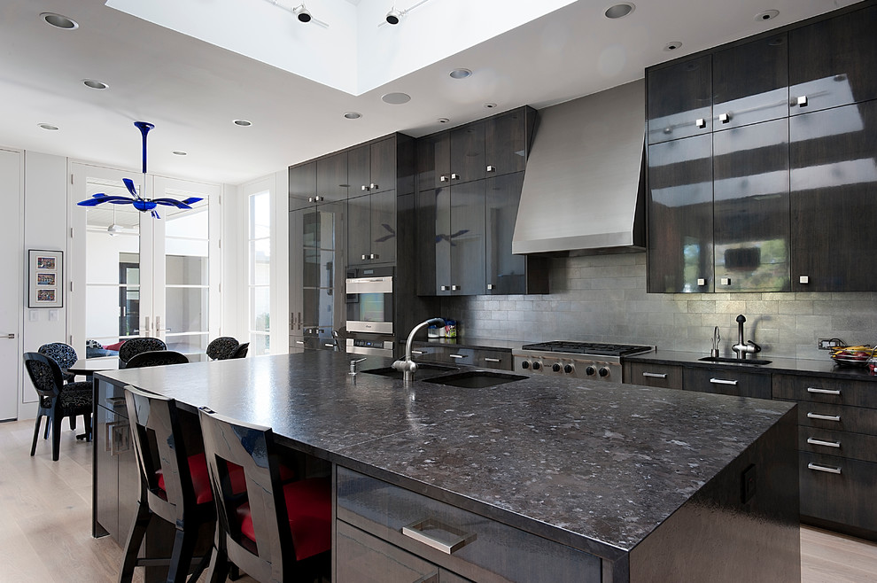 Photo of a contemporary u-shaped eat-in kitchen in Dallas with an integrated sink, flat-panel cabinets, dark wood cabinets, granite benchtops, metallic splashback, ceramic splashback and stainless steel appliances.
