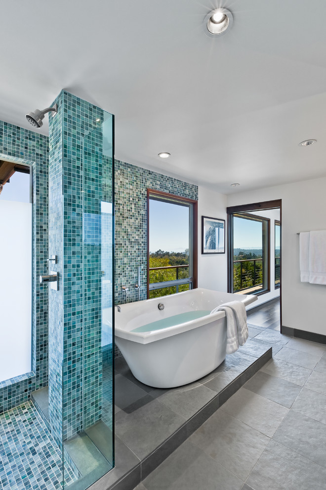 Large midcentury master bathroom in Santa Barbara with a freestanding tub, a corner shower, flat-panel cabinets, medium wood cabinets, blue tile, gray tile, green tile, multi-coloured tile, glass sheet wall, white walls, an undermount sink, grey floor, a hinged shower door and white benchtops.