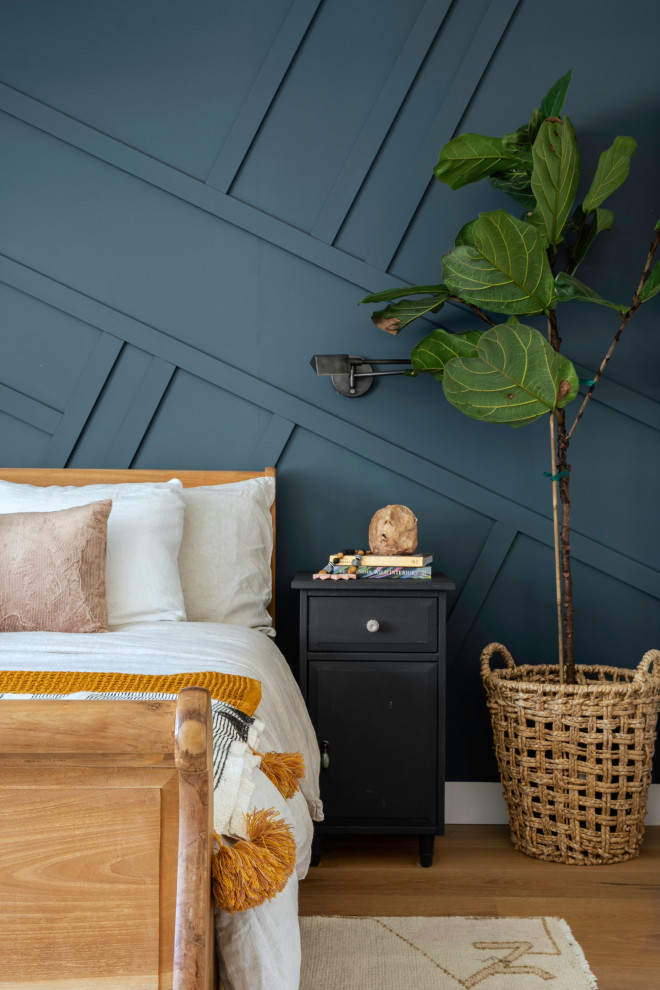 Inspiration for a mid-sized country master bedroom in San Francisco with blue walls, light hardwood floors and panelled walls.